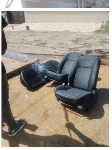 Removed car seats rinsed outdoors as part of interior valet service.